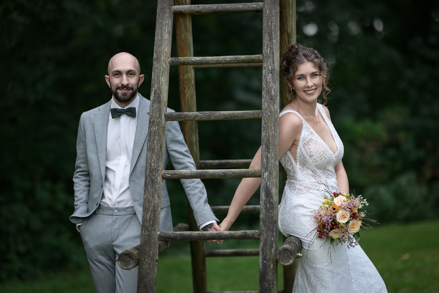Brautpaar im Freien, Hand in Hand – romantisches Hochzeitsbild mit Leiter