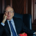 Mann im Anzug im Ledersessel bei einem Business-Interview im edlen Büro