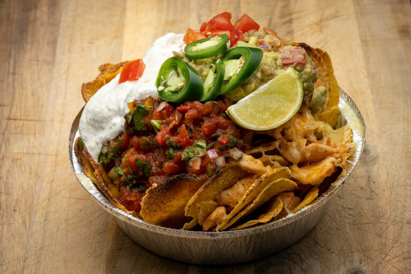 Foodfotografie einer frischen Nacho-Bowl mit Sour Cream, Jalapeños, Salsa und Limette – Ulrich Roth
