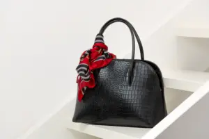 Produktfotografie einer schwarzen Handtasche mit rotem Tuch, stilvoll präsentiert – Ulrich Roth Businessfotografie