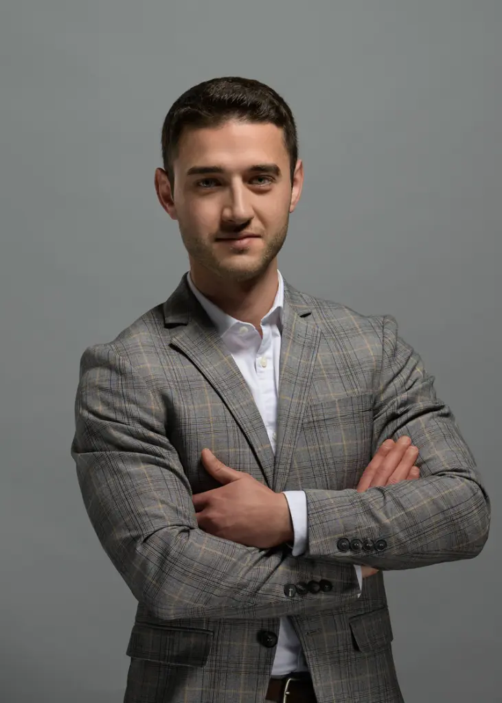 Businessportrait Mann im grauen Anzug – Ulrich Roth Fotografie Business Portrait eines jungen Mannes im grauen Anzug vor neutral grauem Hintergrund, fotografiert von Ulrich Roth.