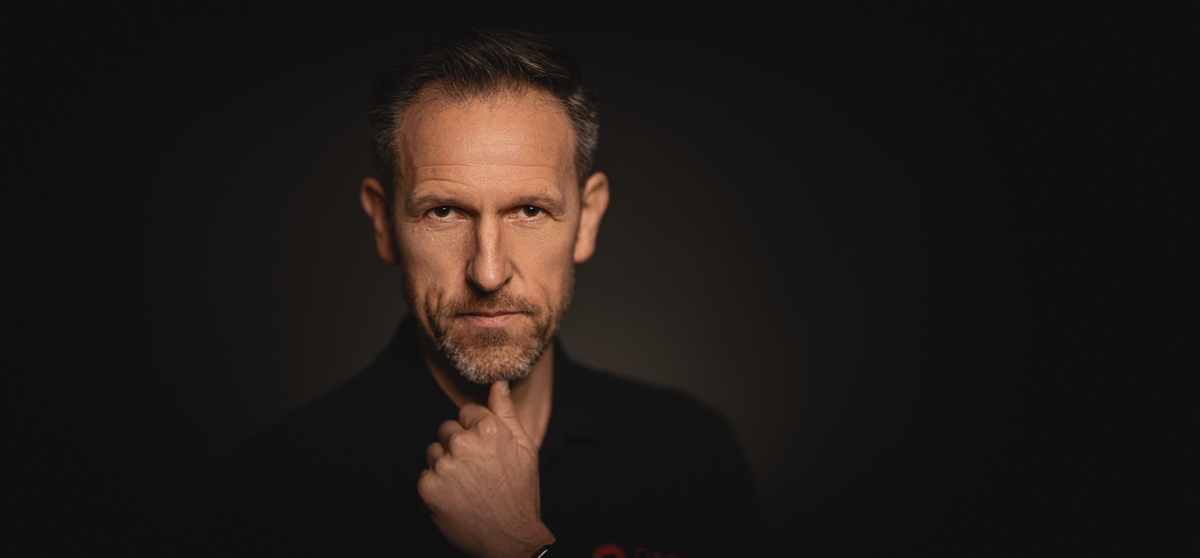 Business Portrait eines Mannes vor dunklem Hintergrund, fotografiert von Ulrich Roth