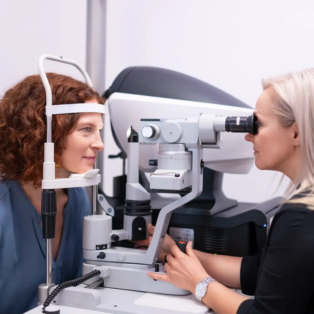 Augenoptikerin führt eine Augenuntersuchung mit modernem Gerät bei einer Kundin durch, fotografiert von Ulrich Roth