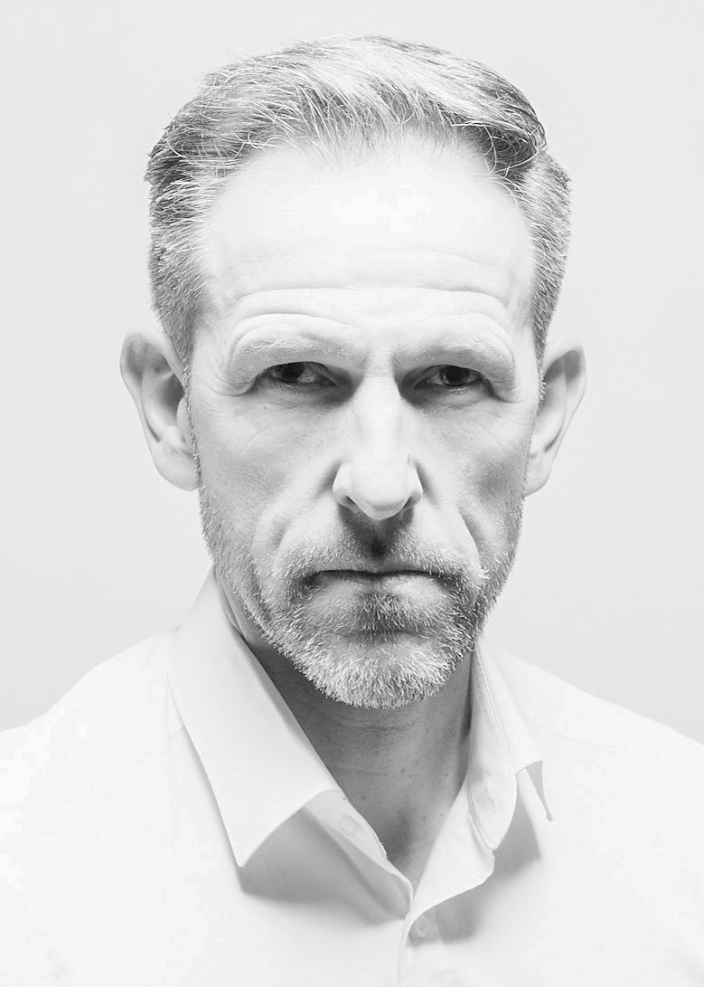 Reduziertes Portrait in hellem Licht mit direktem Blick und klaren Konturen.