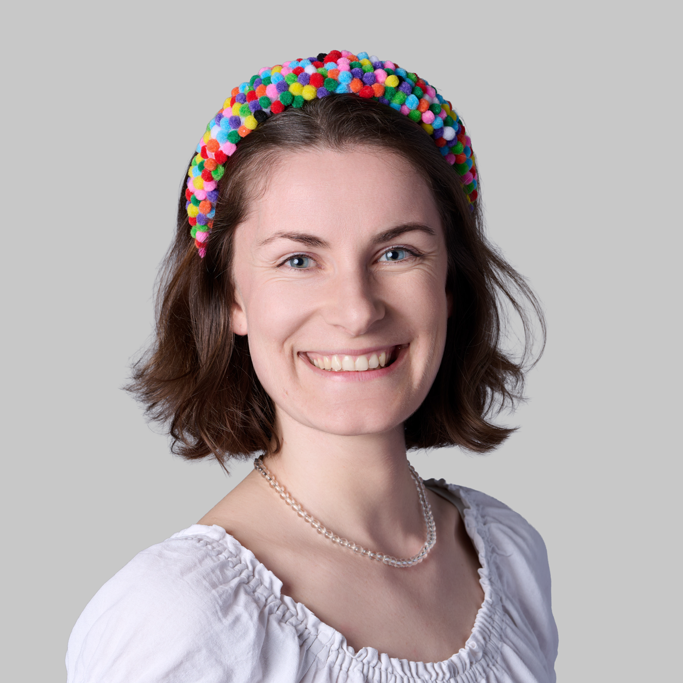 Corporate Headshot einer Mitarbeiterin vor neutralem Hintergrund