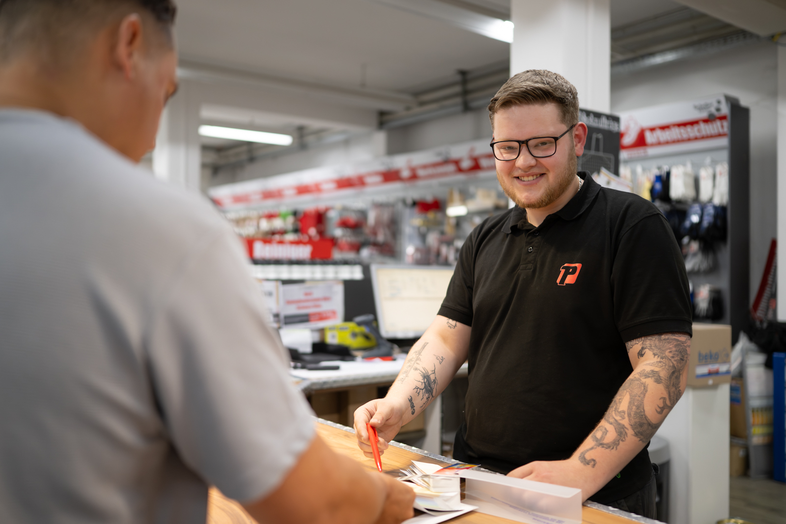 Mitarbeiter berät einen Kunden an einer Verkaufstheke