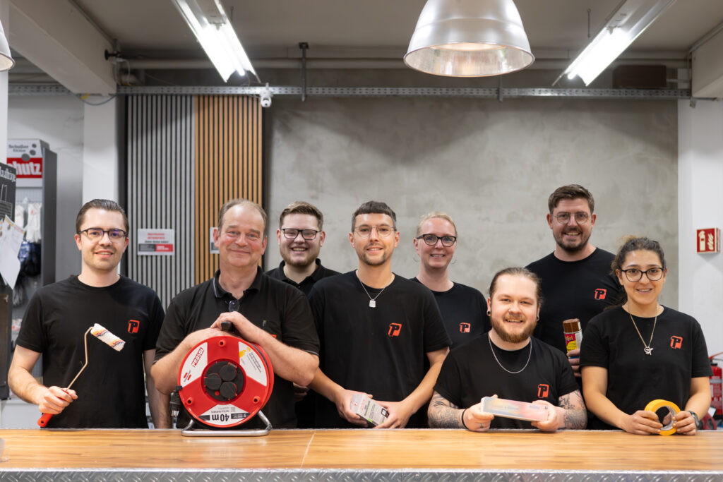 Mitarbeiterteam eines technischen Fachhandels hinter einer Werkbank