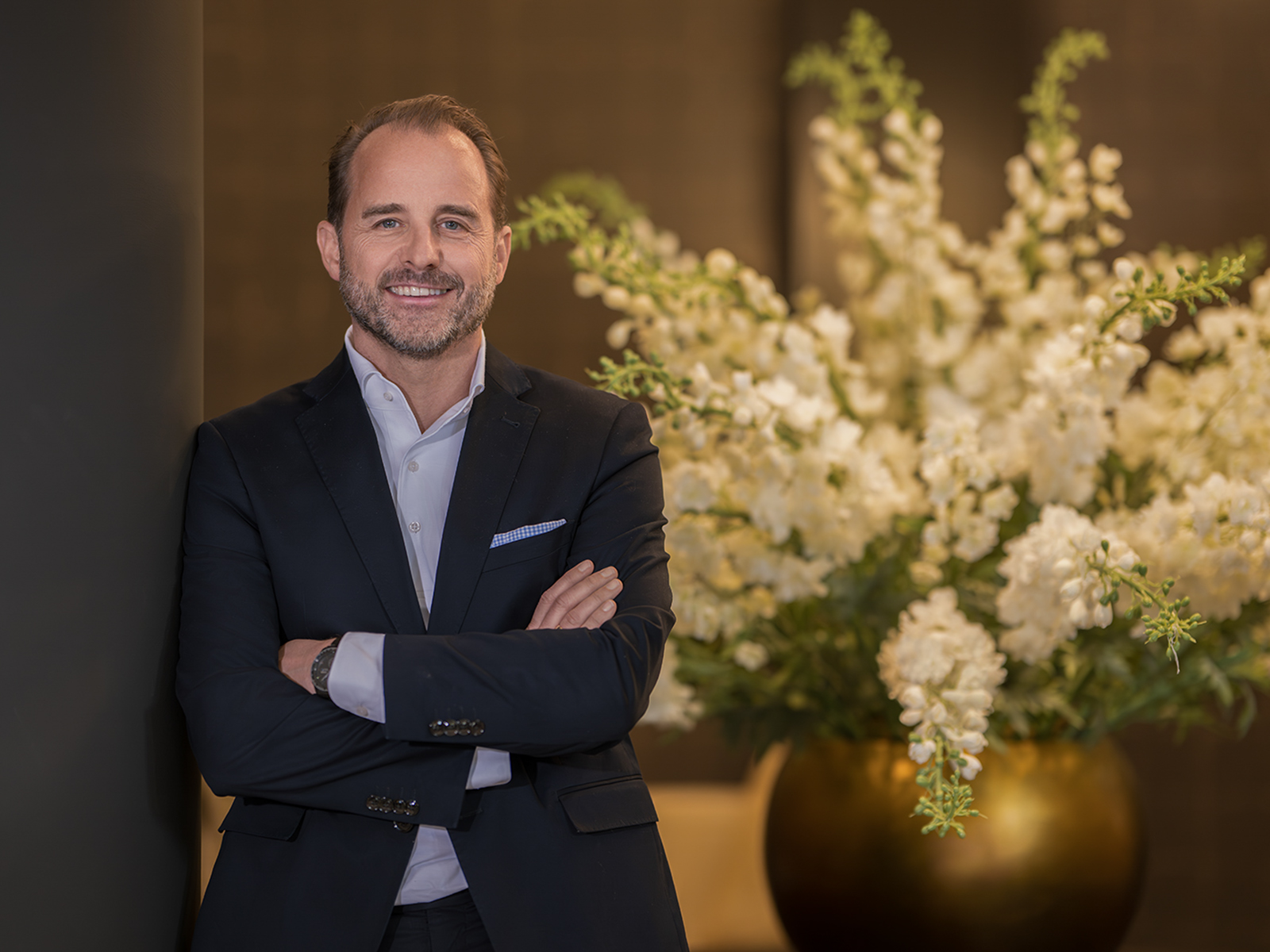 Geschäftsführer in Businesskleidung vor hochwertigem Hoteldesign