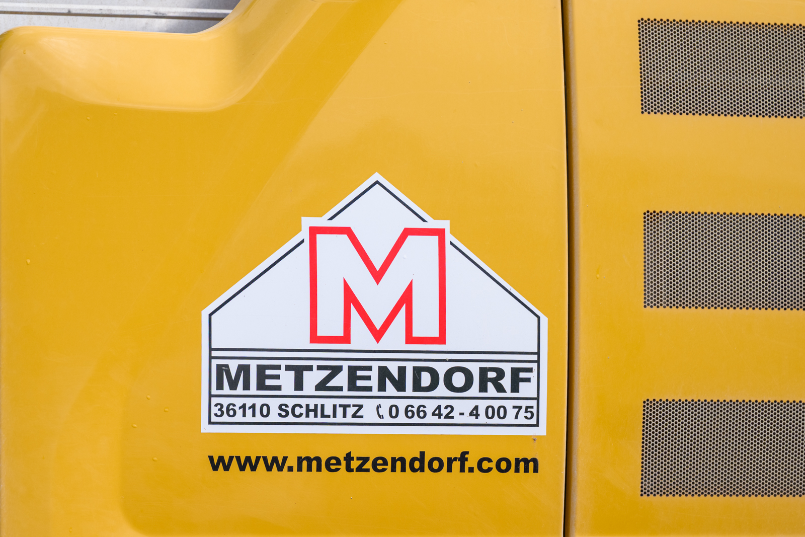Baumaschine mit Firmenlogo und Kontaktdaten