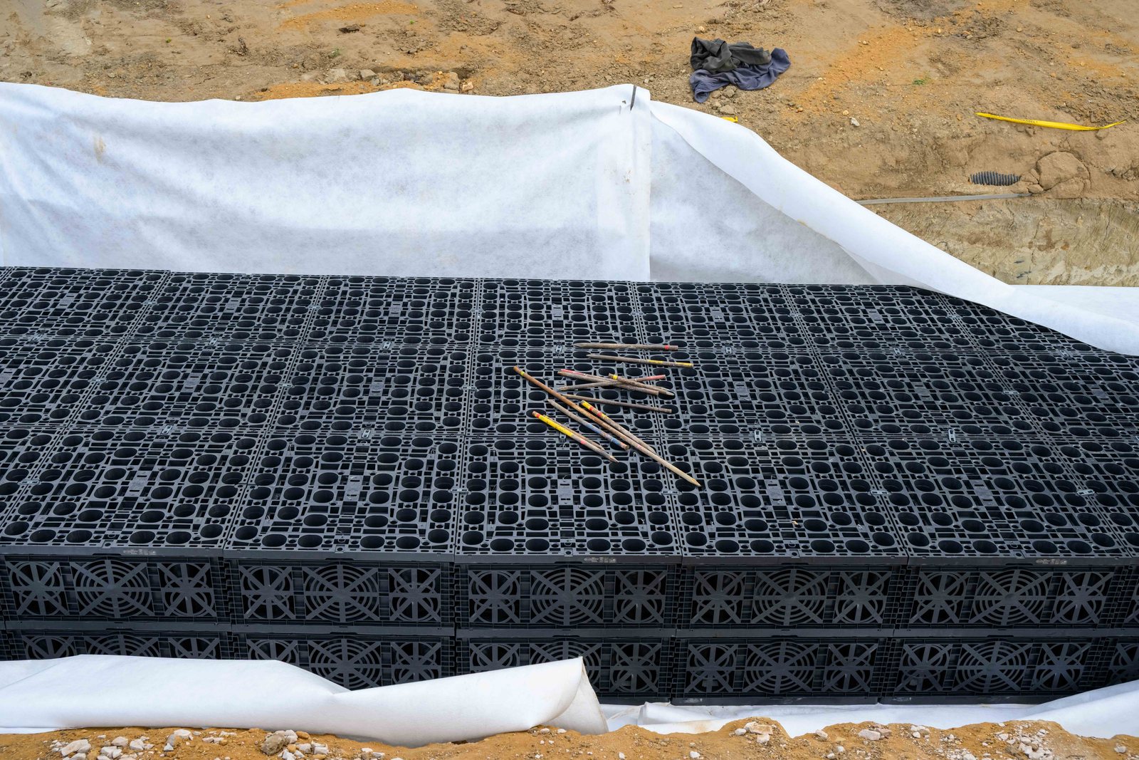 GRAF EcoBloc Speicherblöcke auf weißem Vlies in der Baugrube, darauf Holzpflöcke