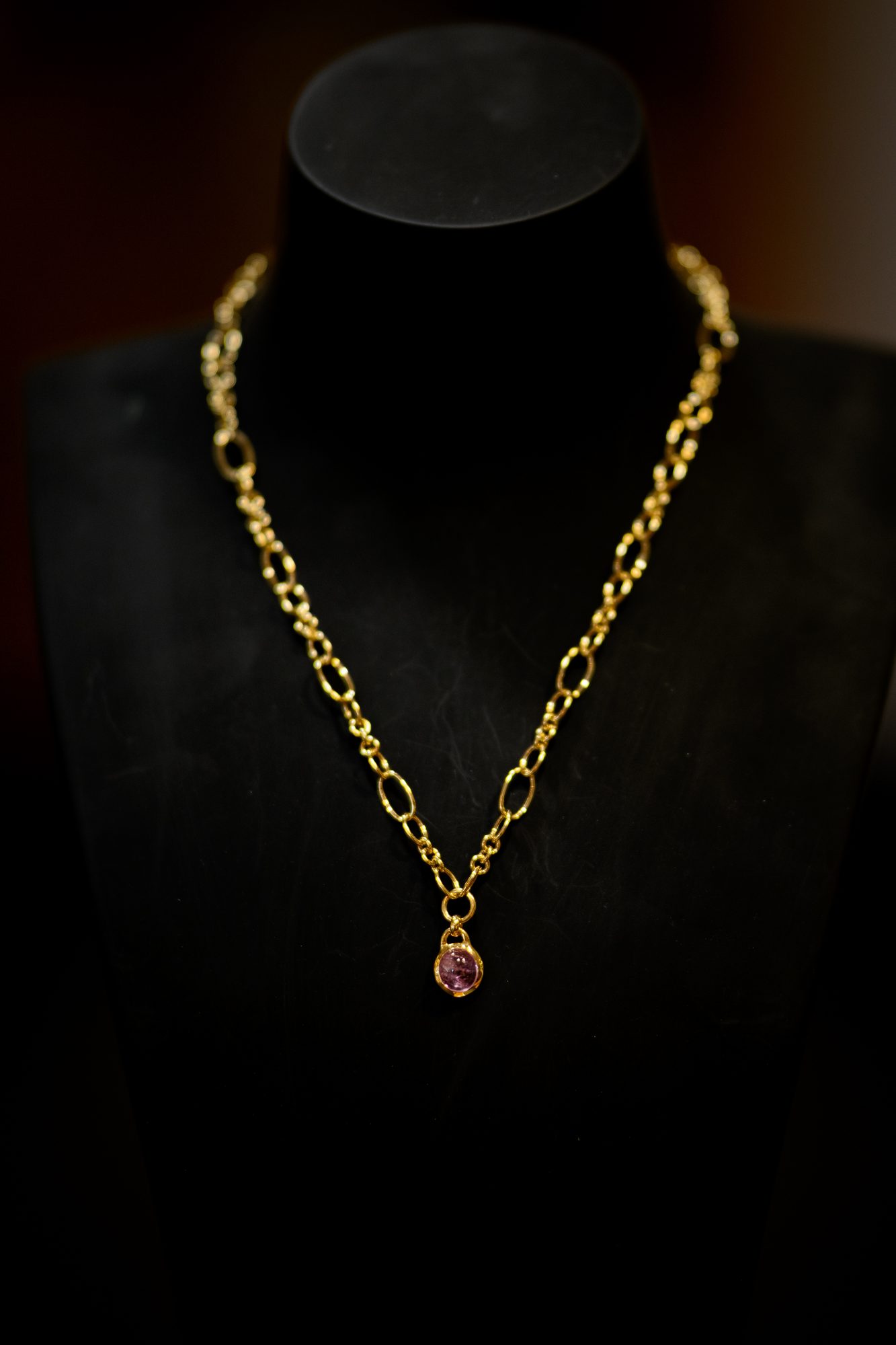 Goldkette mit Anhänger auf schwarzer Schmuckbüste