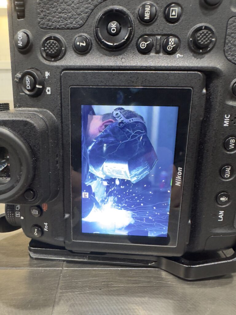 Display einer Nikon-Kamera zeigt einen Schweißer mit Schutzmaske im Funkenflug
