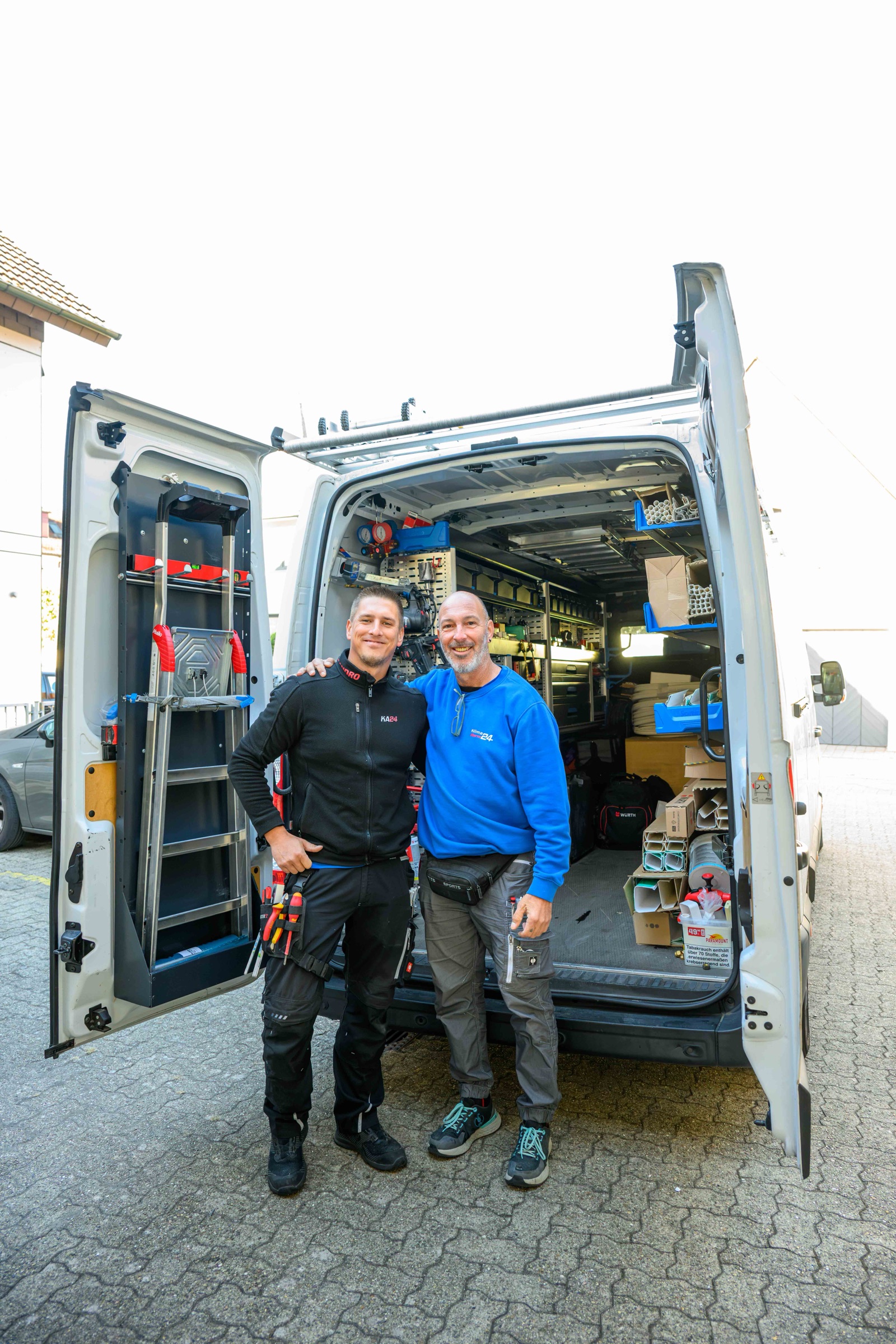 Zwei Kollegen eines Handwerksbetriebs am Servicefahrzeug – Mitarbeiterfotos Karlsruhe