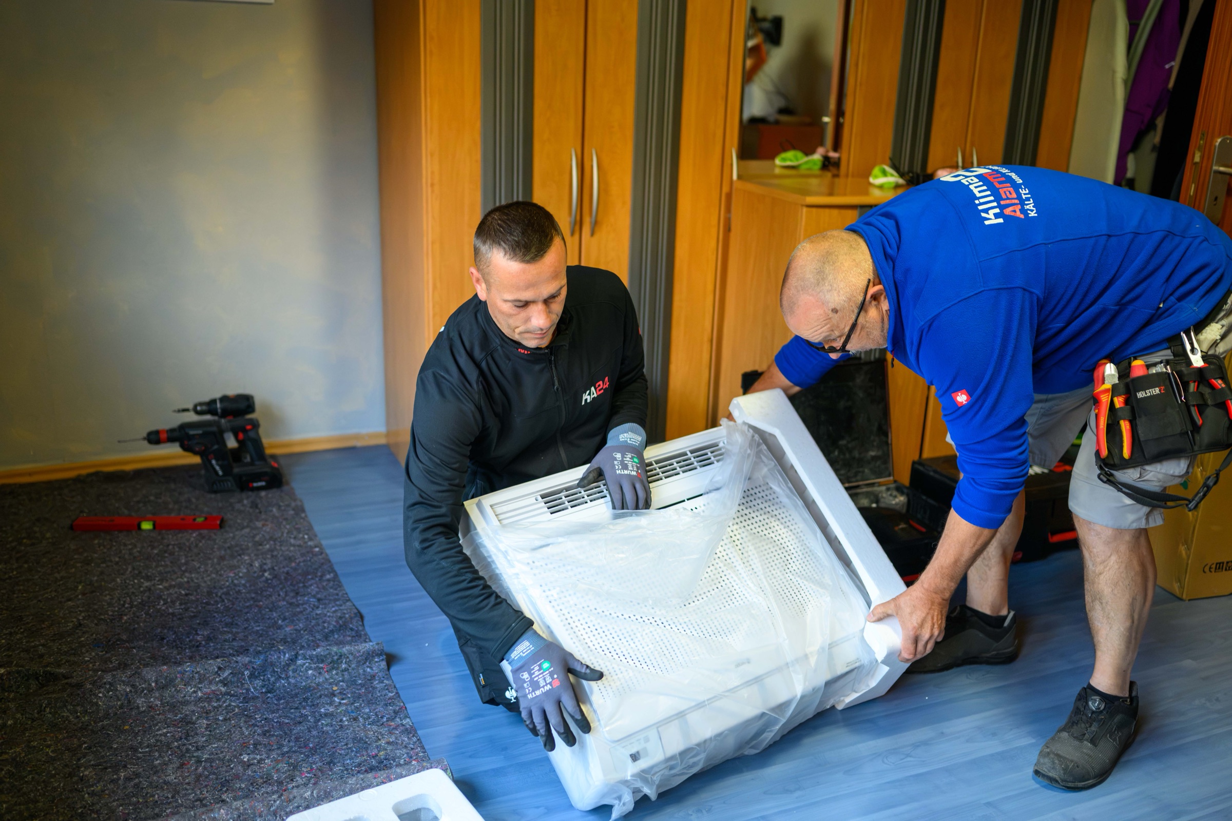 Zwei Monteure bereiten ein Klimagerät für die Montage vor – Unternehmensfotograf Karlsruhe